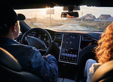 Zwei Personen sitzen in einem Auto.