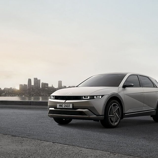 Grauer Hyundai Ioniq 5 vor Stadtkulisse.